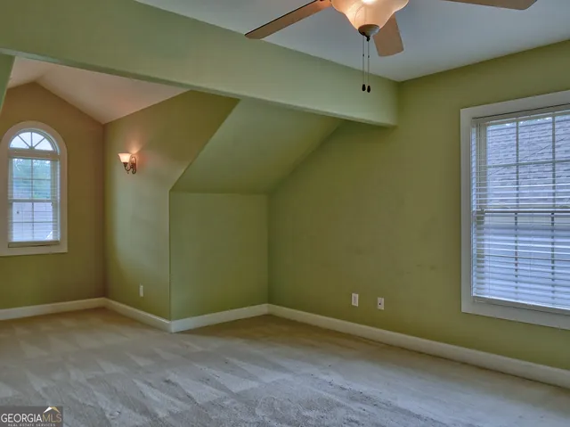 an empty room with a ceiling fan and a window