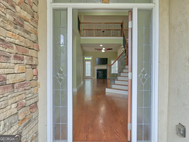 a view of a hallway with wooden floor and a bathroom