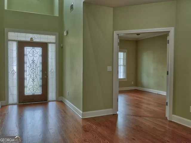 an empty room with wooden floor and a window