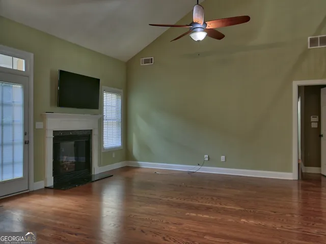 a view of empty room with wooden floor and fireplace