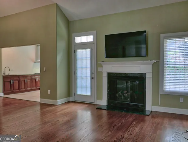 a view of a livingroom with wooden floor and a fireplace
