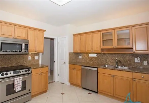 a kitchen with stainless steel appliances granite countertop a stove a sink and a microwave