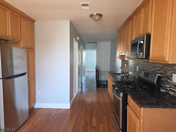 a kitchen with stainless steel appliances a stove a microwave and sink