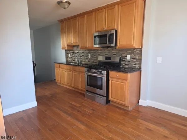 a kitchen with a refrigerator and a stove top oven