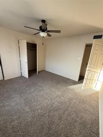 an empty room with windows and fan