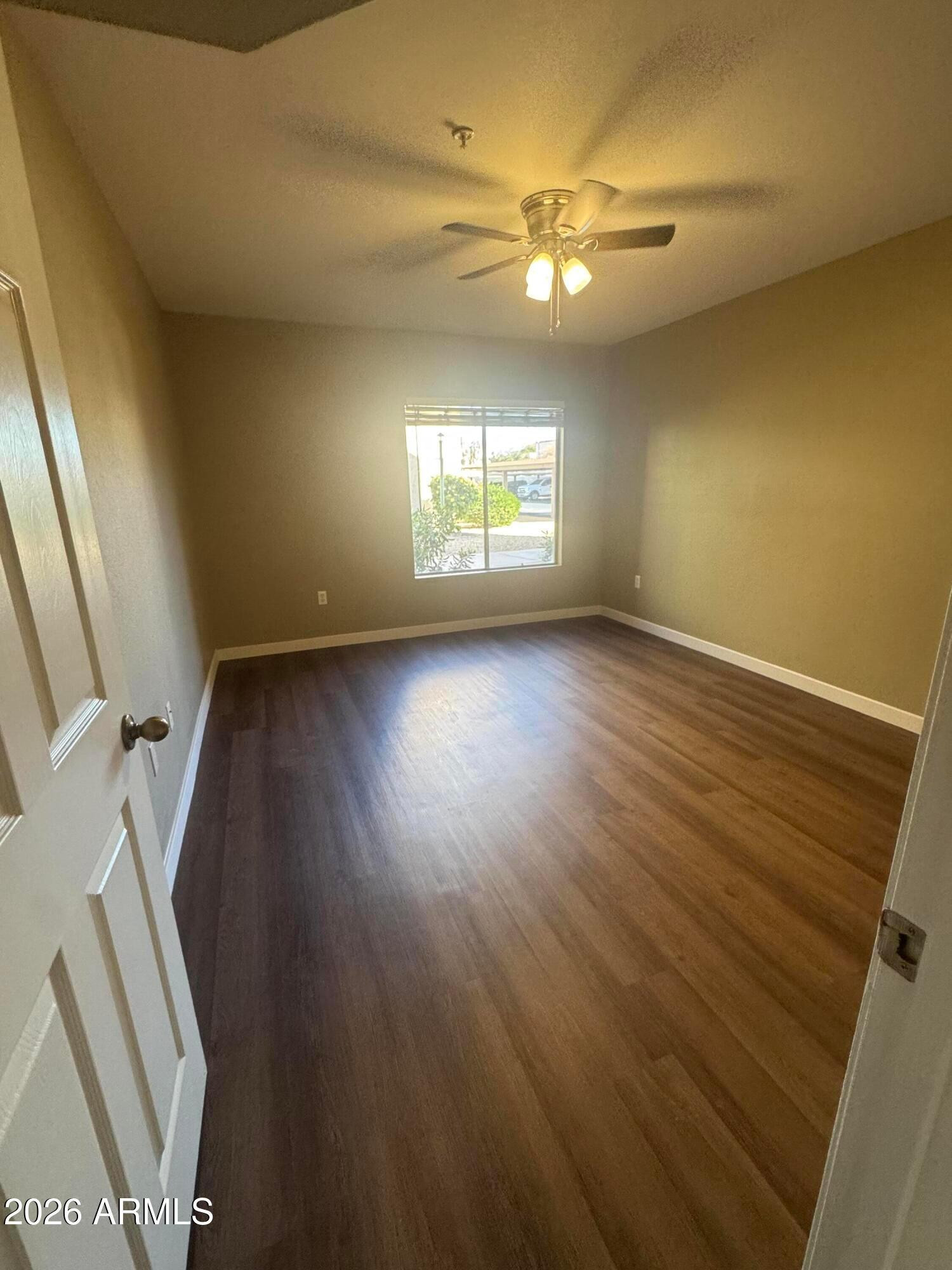 1295 North Ash Street, Unit 612 Gilbert, AZ 85233 - Photo 4 of 10 an empty room with wooden floor and windows