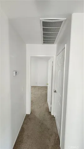 an empty room with a chandelier fan and windows