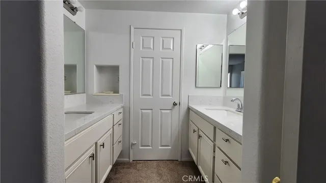 a bathroom with a double vanity sink and mirror
