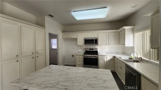 a kitchen with a sink stove top oven and cabinets