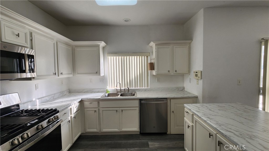 1496 Dusty Hill Road Hemet, CA 92545 - Photo 27 of 31 a kitchen with a sink stove top oven and cabinets
