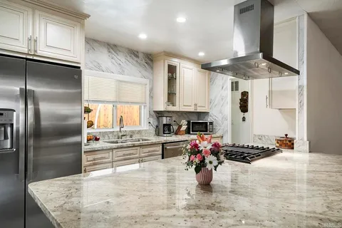 a kitchen with stainless steel appliances granite countertop a sink stove and refrigerator