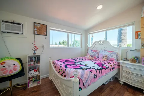 a bedroom with a bed a window and dresser