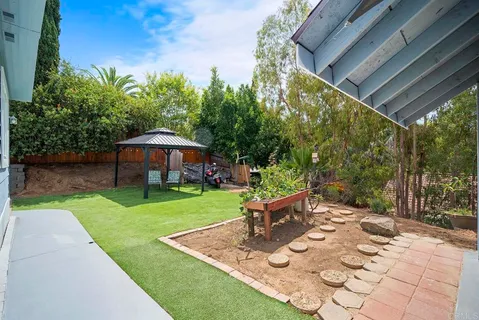 a view of backyard with a table and chair under an umbrella