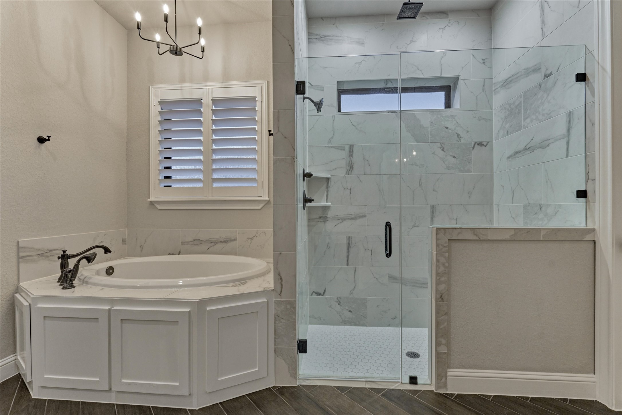 11618 Renaissance Drive Montgomery, TX 77356 - Photo 20 of 49 A closer look at the soaking tub reveals a coordinating chandelier that complements the bedroom fixture. The spacious walk-in shower is enclosed in seamless glass and features a built-in bench and convenient toiletry niche.