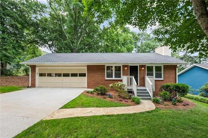 a front view of a house with a garden and yard