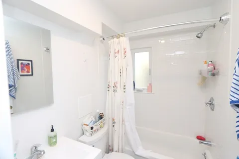 a bathroom with a tub shower vanity and a sink