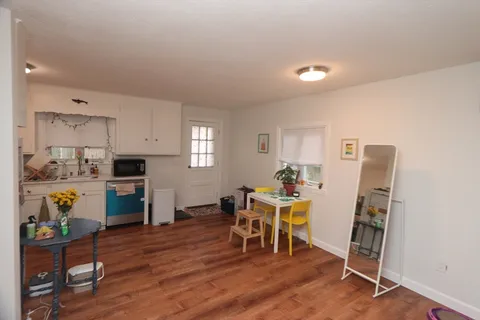 a view of a dining room with furniture a rug and wooden floor