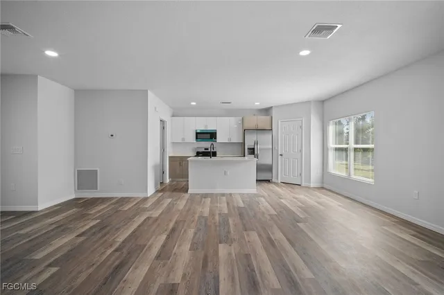 a view of a kitchen with wooden floor and windows