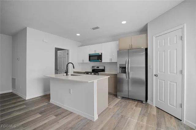 a kitchen with stainless steel appliances granite countertop a refrigerator a sink and a stove