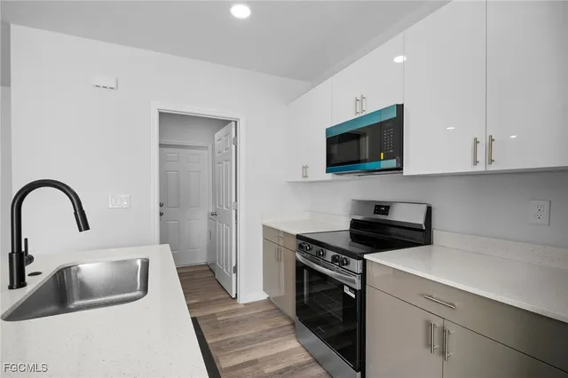 a kitchen with sink a stove and microwave