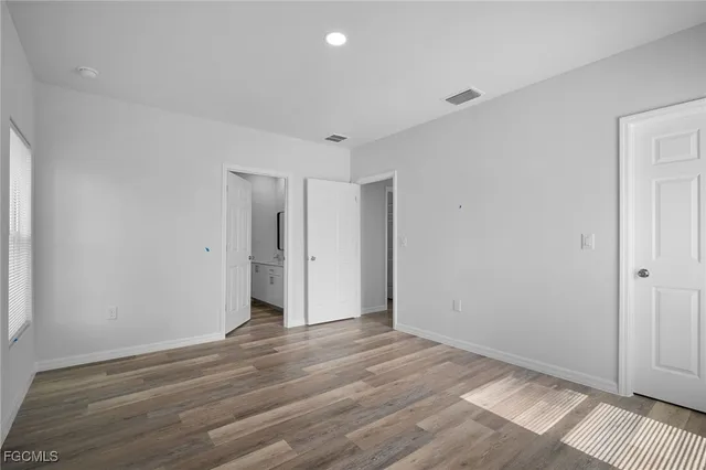 a view of a room with wooden floor and a ceiling fan