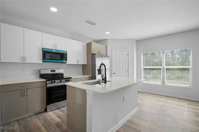 a kitchen with stainless steel appliances granite countertop a sink stove and refrigerator