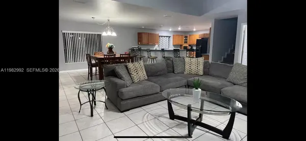 a living room with furniture and kitchen view