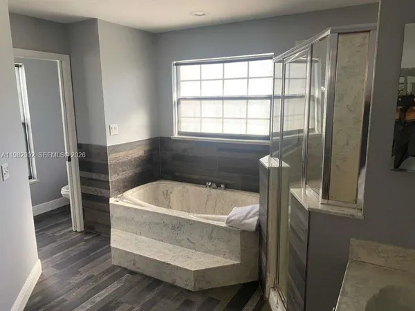 a bathroom with a tub a sink and a window