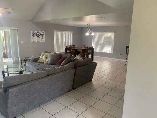 a living room with furniture and a floor to ceiling window