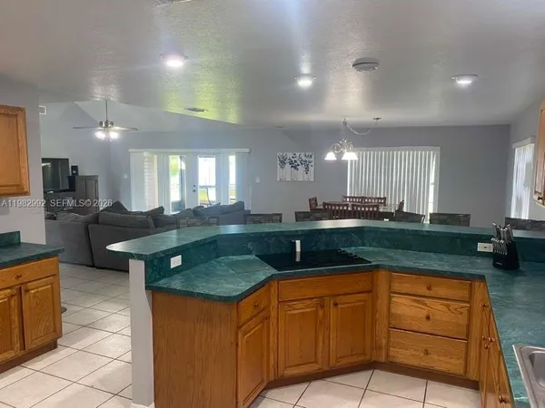 a kitchen with granite countertop a sink white cabinets and dining table
