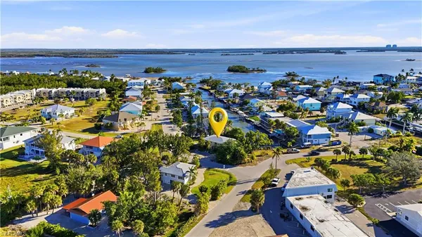 an aerial view of ocean and residential houses with outdoor space