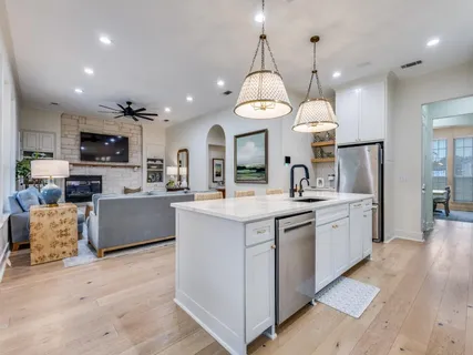 a kitchen with stainless steel appliances granite countertop a sink a stove top oven a kitchen island a stove and a sink