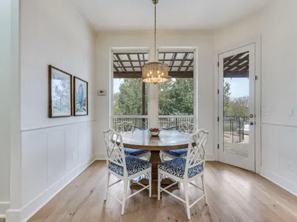 a dining room with furniture a chandelier and wooden floor