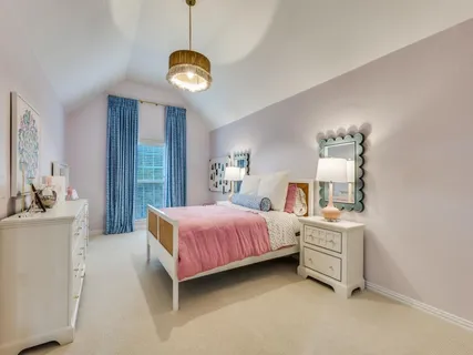a spacious bedroom with a bed and a chandelier