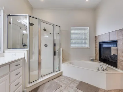 a spacious bathroom with a tub a double vanity sink a mirror and a shower