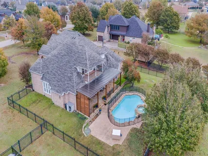 an aerial view of a house with garden space and a swimming pool