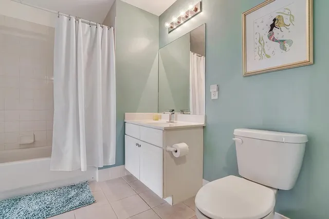 a bathroom with a granite countertop sink a toilet and bathtub