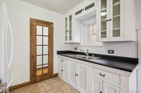 a kitchen with granite countertop white cabinets and window