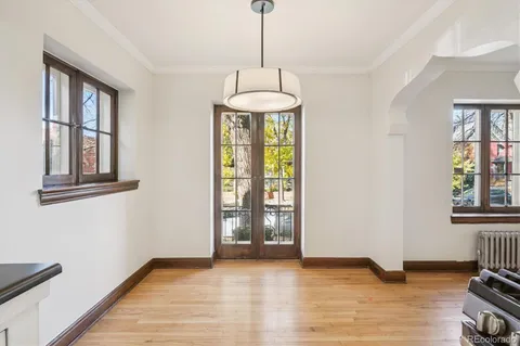 a view of an empty room with window and hardwood floor