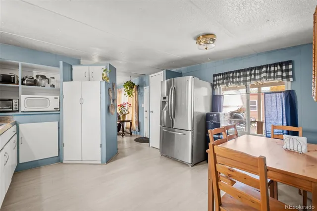 a kitchen with refrigerator and cabinets