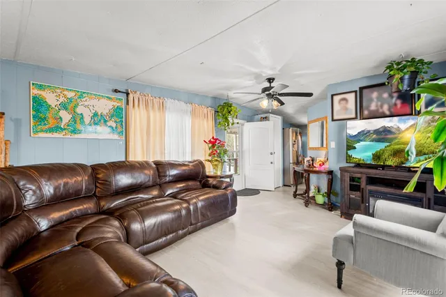 a living room with furniture a ceiling fan and a window