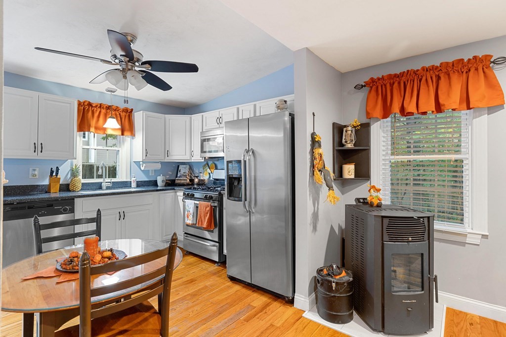 31 Reid Road Douglas, MA 01516 - Photo 9 of 31 a kitchen with stainless steel appliances a refrigerator a stove a sink dishwasher and a dining table with chairs