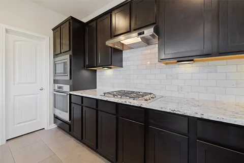 a kitchen with stainless steel appliances granite countertop a refrigerator and a stove