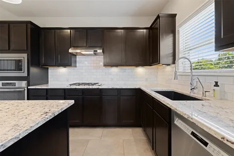 a kitchen with granite countertop a sink and a stove