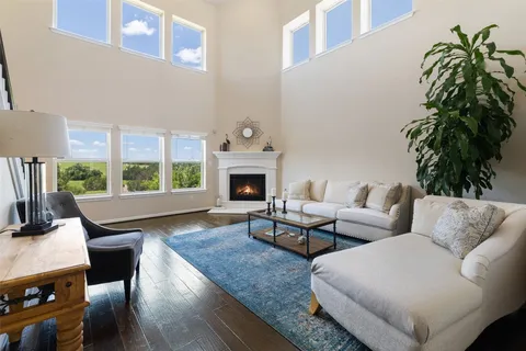 a living room with furniture a fireplace and a potted plants with wooden floor
