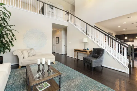 a living room with furniture and a table with wooden floor