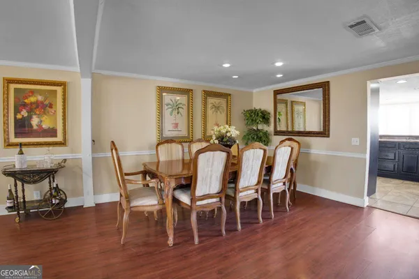 a view of a a dining room with furniture window and wooden floor