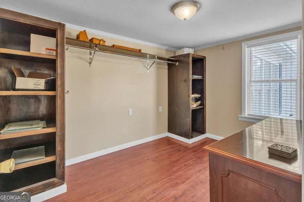 a view of an empty room with cabinet and a window
