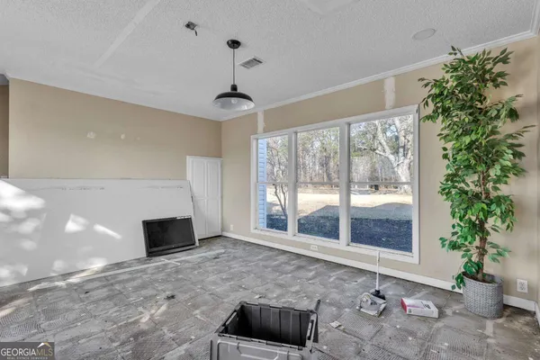 an empty room with windows and ceiling fan