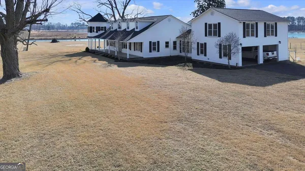 a view of house with yard and sitting area